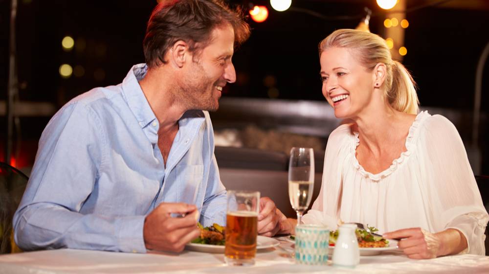 Couple eating dinner at rooftop restaurant | Why Don't We Take Better Care of Ourselves? | featured
