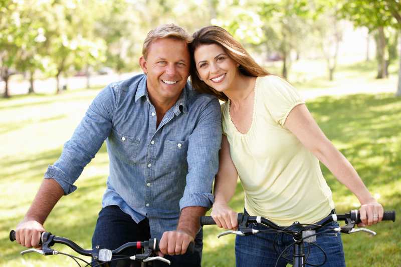 Couple riding bikes in park| Take Better Care of Ourselves