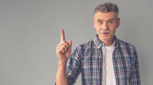 Handsome mature man in casual wear is holding finger erect | Harder Erections in Your Golden Years | featured