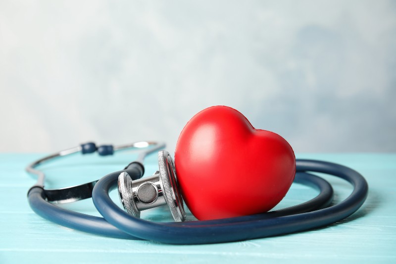 Stethoscope and red heart on wooden table | health benefits of curcumin