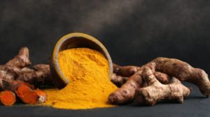 Turmeric powder and fresh turmeric on wooden background | 13 Astounding Curcumin Health Benefits [Including Neutralizing COVID] | featured