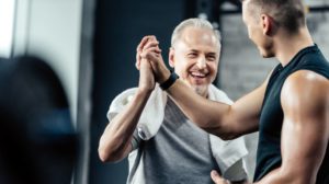 senior sportsman giving highfive to trainer in sport center | Seniors Fitness - Dial In Your Fitness Starting Point | featured