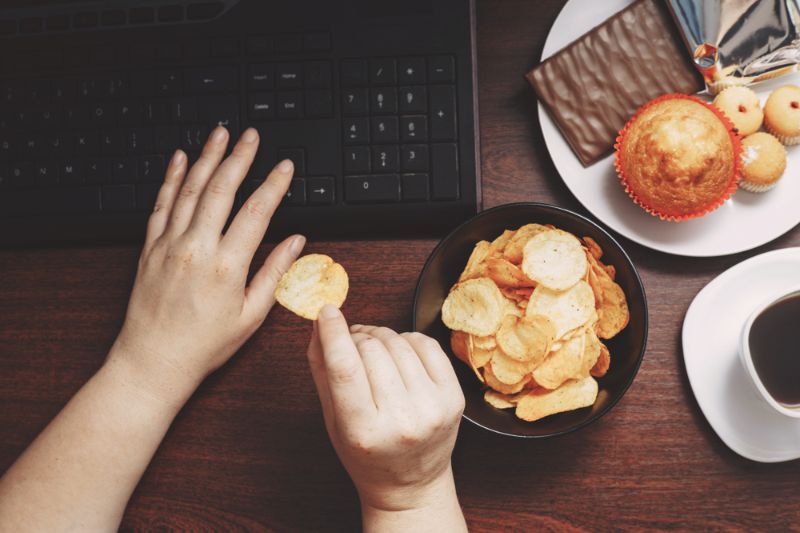 unhealthy-snack-workplace-hands-woman-working Eating Habits