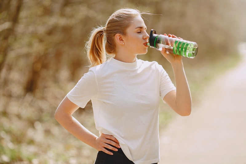 woman in white crew neck t shirt drinking from green plastic bottle | lime water benefits