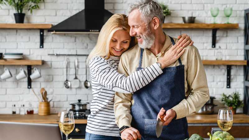 Beautiful mature couple hugging while cooking vegetable salad at kitchen table | How to Reverse Prediabetes Naturally and Permanently?