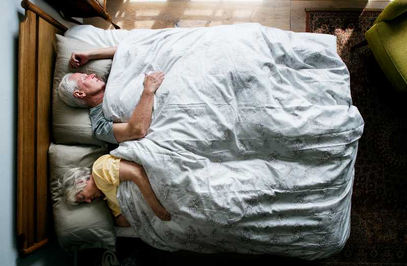 Elderly Caucasian couple sleeping on the bed | Preventative Medicine
