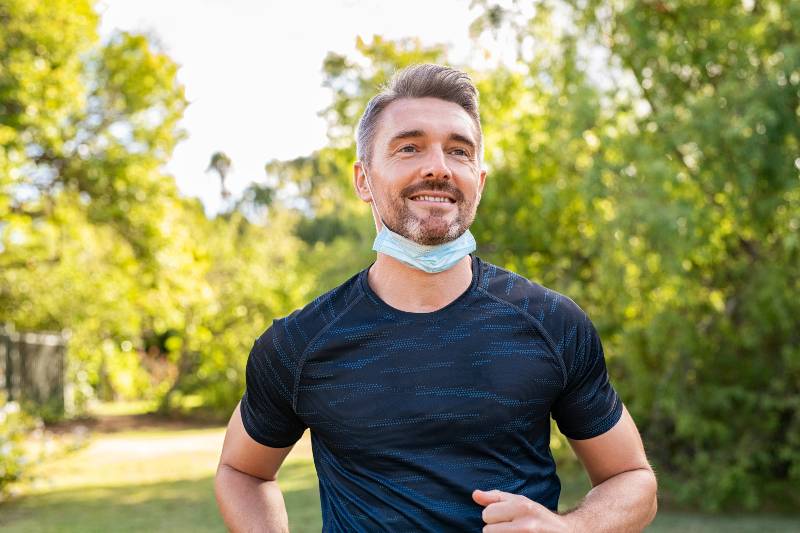 Happy mature man running in park with face mask during covid-19 pandemic | Weight Loss Hacks