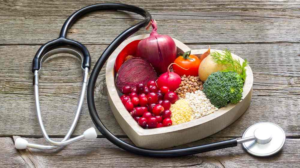 Healthy food in heart and cholesterol diet concept on vintage boards | Protect Your Heart with These 11 Natural Blood Thinners | featured
