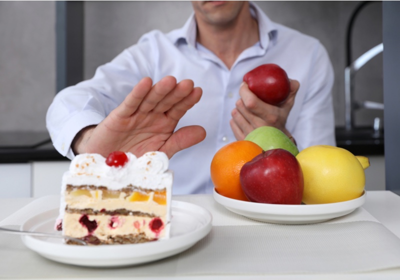 Man refuses to eat unhealthy cake and choose fruits for dessert. Healthy eating and active lifestyle concept | How to reverse prediabetes naturally | Change Your Diet | Reduce Your Carb Intake | How to Reverse Prediabetes Naturally 