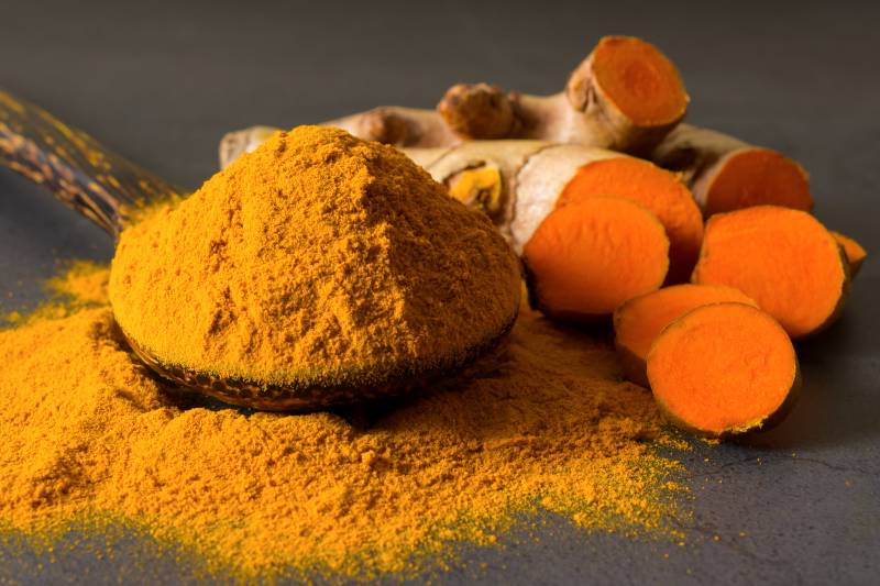 Turmeric (curcumin) powder in a wooden ladle | Natural Blood Thinners