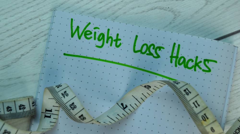 Weight Loss Hacks write on a book | Ten Weight Loss Hacks | featured