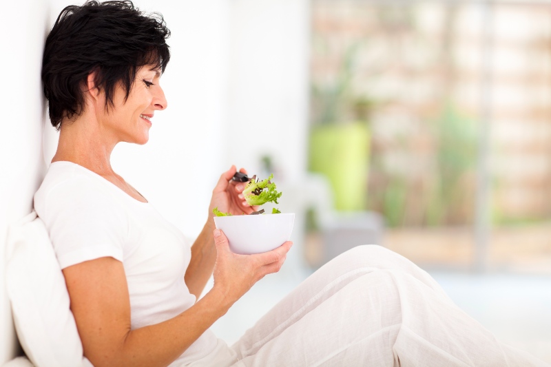 Elegant Middle-Aged Women Sitting on Bed and Eating Salad | Keto for Women over 50