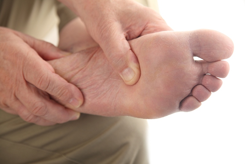 man checks his aching foot | signs of diabetes