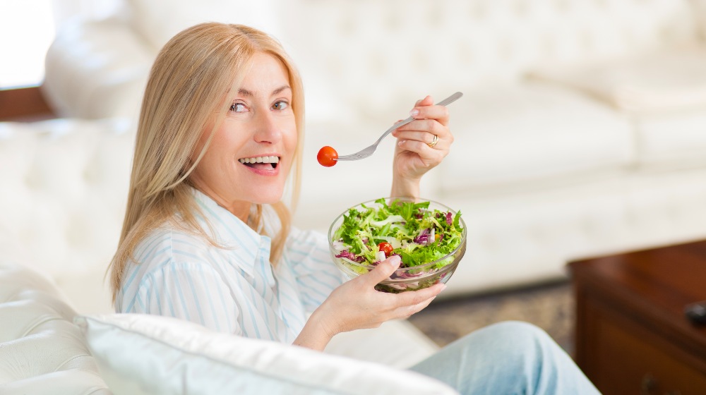 Mature Woman Eating a Healthy Salad on Her Sofa | Keto for Women over 50 | Featured