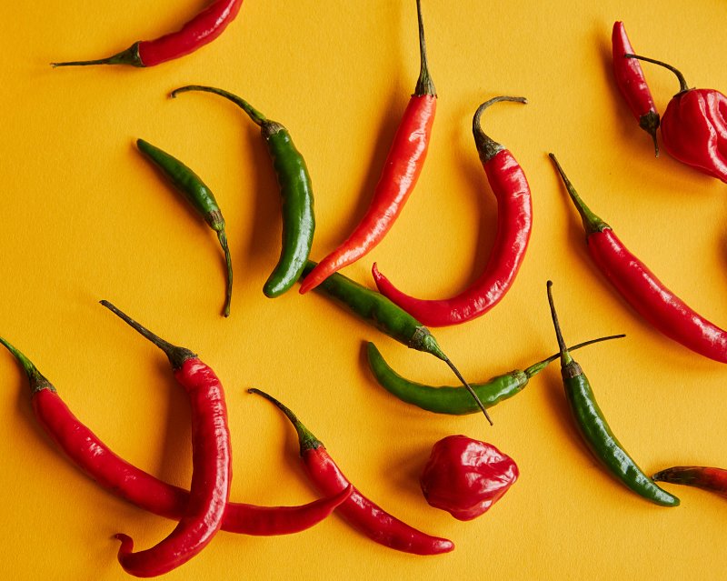red and green peppers on yellow background | burn fat while sleeping