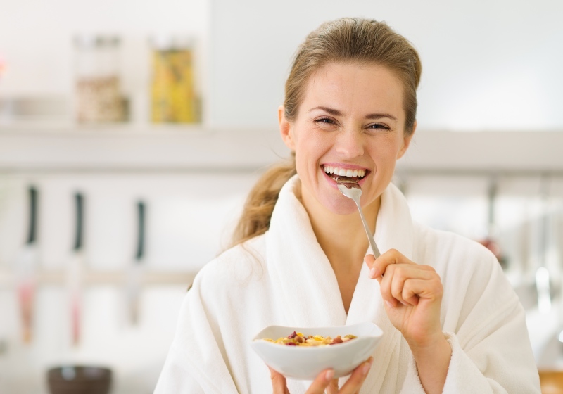 Smiling Young Woman in Bathrobe Eating Healthy Breakfast | How to Reverse Insulin Resistance Naturally