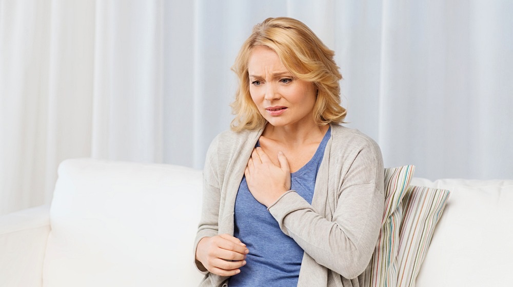 unhappy woman suffering heartache home | Heart Attack vs Angina | Angina vs Heart Attack | Featured