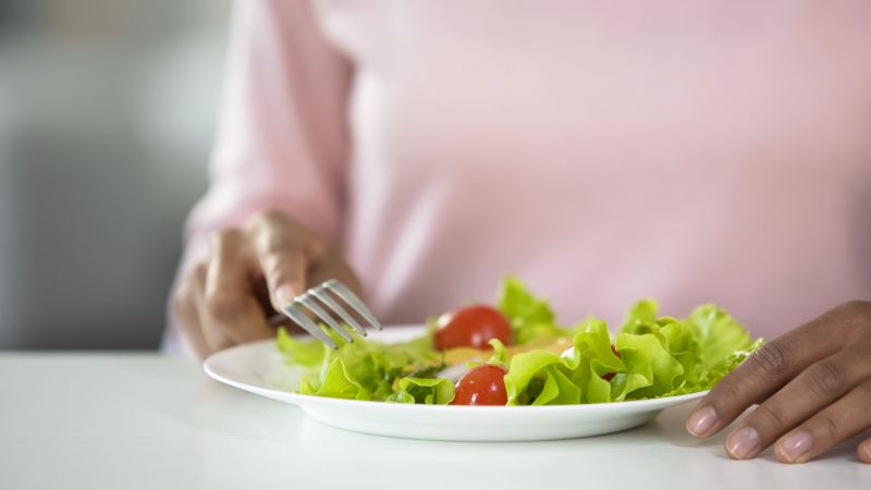 woman-eating-vegetable-salad-close-healthy dietary habits