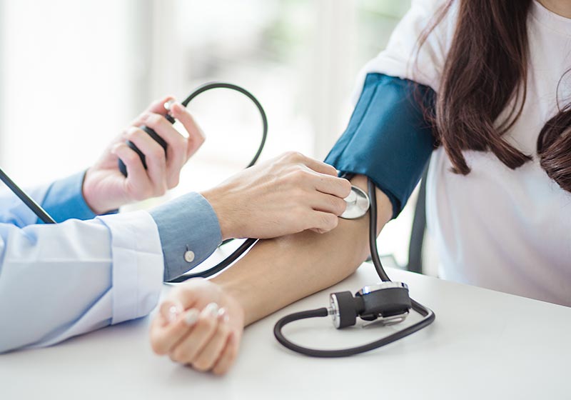 Doctor checking a patient's blood pressure | Is Tylenol a Blood Thinner?