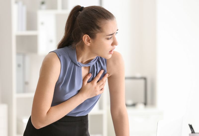 Young woman suffering heart attack office | Can a heart attack cause brain damage