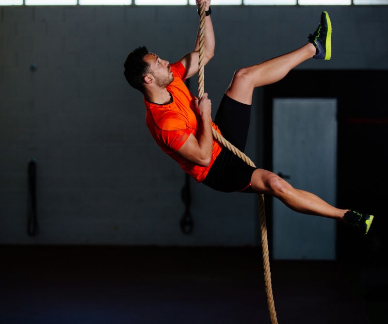 athlete man climbing rope gym beastmode