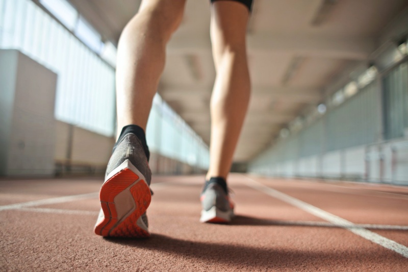 fit runner standing on racetrack in athletics arena | congestive heart failure leg cramps