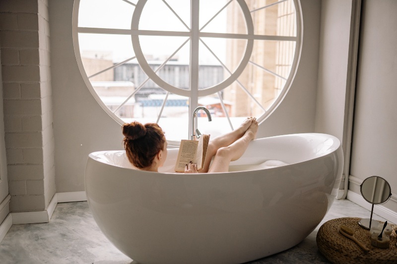 Woman Reading a Book While in a Bathtub | Bag Lady Syndrome
