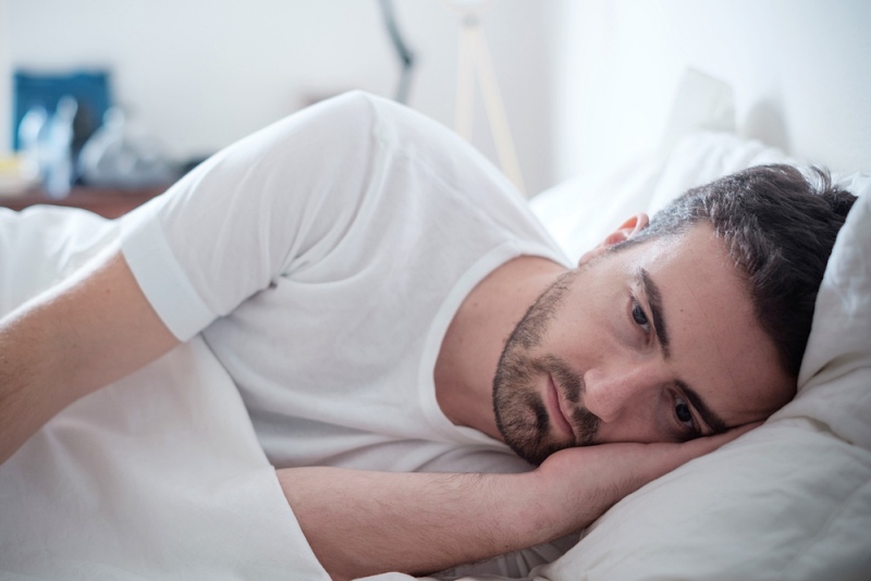 depressed man lying his bed feeling | erectile dysfunction