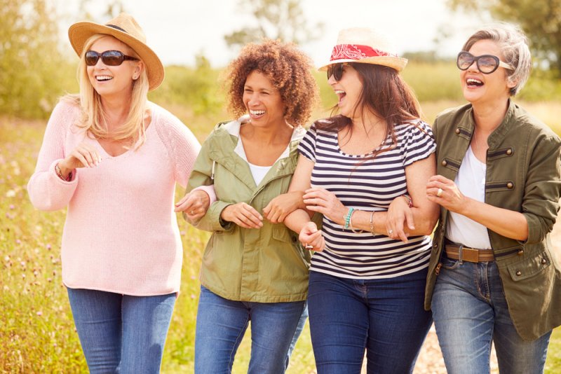 group mature female friends walking along | coming to terms with turning 50