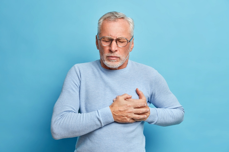 senior man spectacles presses hand chest | how is the cardiovascular system affected by aging