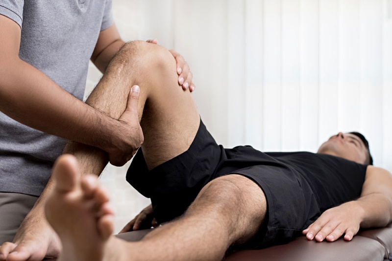 therapist treating injured knee athlete male | pelvic floor muscles
