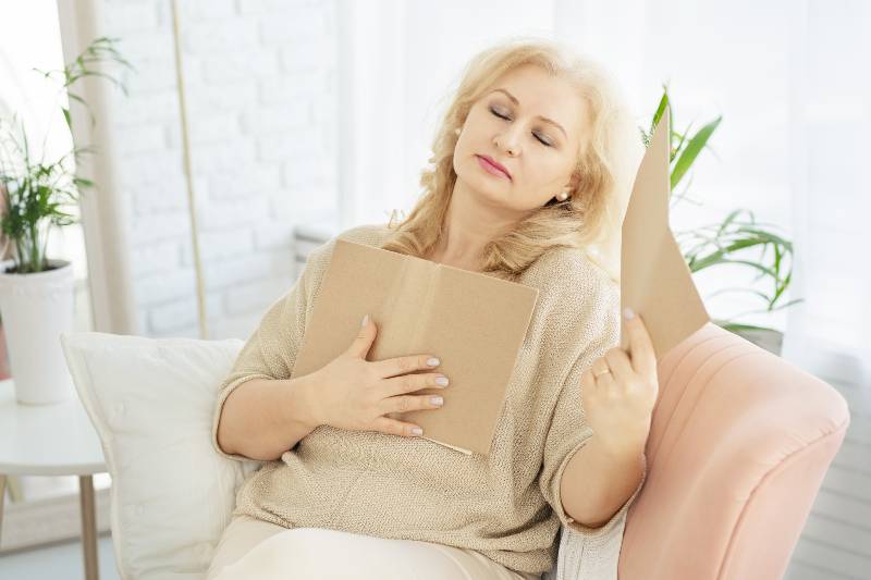 A middle-aged woman woman feels bad because of menopause. She needs support. Hot flashes | Why Hot Flashes Happen