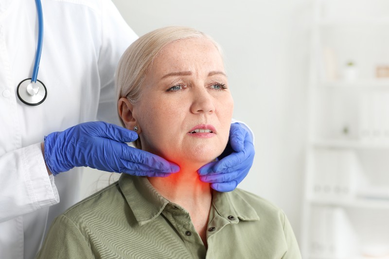 Endocrinologist examining senior woman with thyroid gland problem in clinic | Hypothyroidism & Hot Flashes