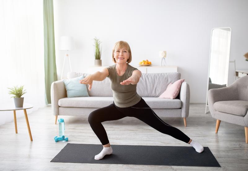 Happy senior lady doing lunges on domestic workout in living room | Lecithin is involved in your lungs.