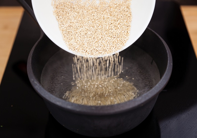 How to Make Quinoa _ Quinoa Cooking Instructions _ Bowl pouring raw quinoa grains into boiling water | Quinoa easy and healthy cooking at home