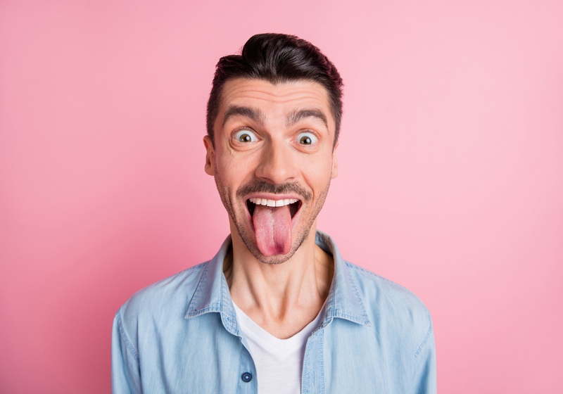 Tongue Color | Tongue Color Meaning | What Does the Color of Your Tongue Mean | _ Close-up portrait of nice cheerful crazy humorous guy showing tongue out isolated over pink pastel color background